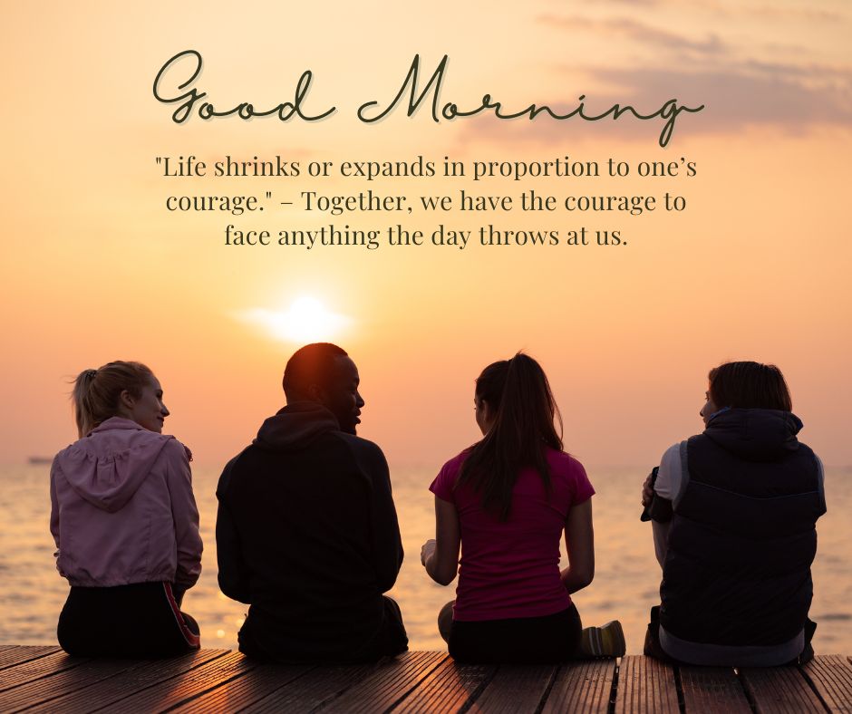 Four people sitting on a dock facing a sunrise over water, exuding a sense of calm and camaraderie. The image includes an inspirational "Good Morning" quote about life and courage.