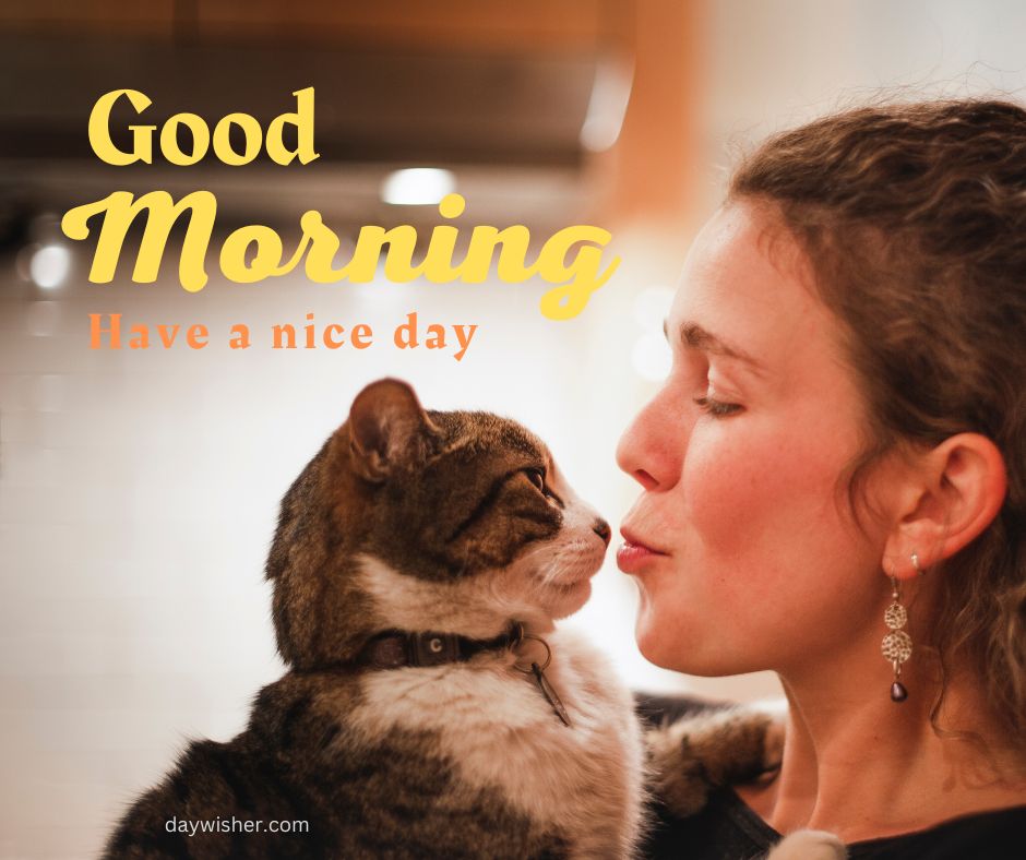 A woman affectionately kisses a cat on the nose. The image includes a "good morning, have a nice day" text overlay and the logo "daywisher.com". The background is softly blurred