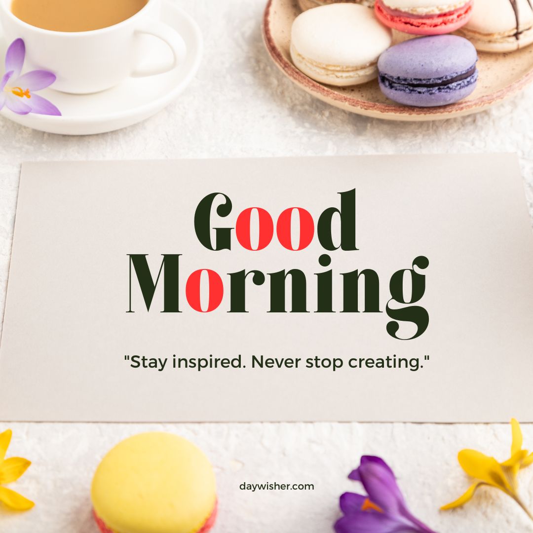 A motivational "good morning" card featuring the quote "stay inspired. never stop creating." surrounded by colorful macarons, a cup of tea, and spring flowers on a light background.