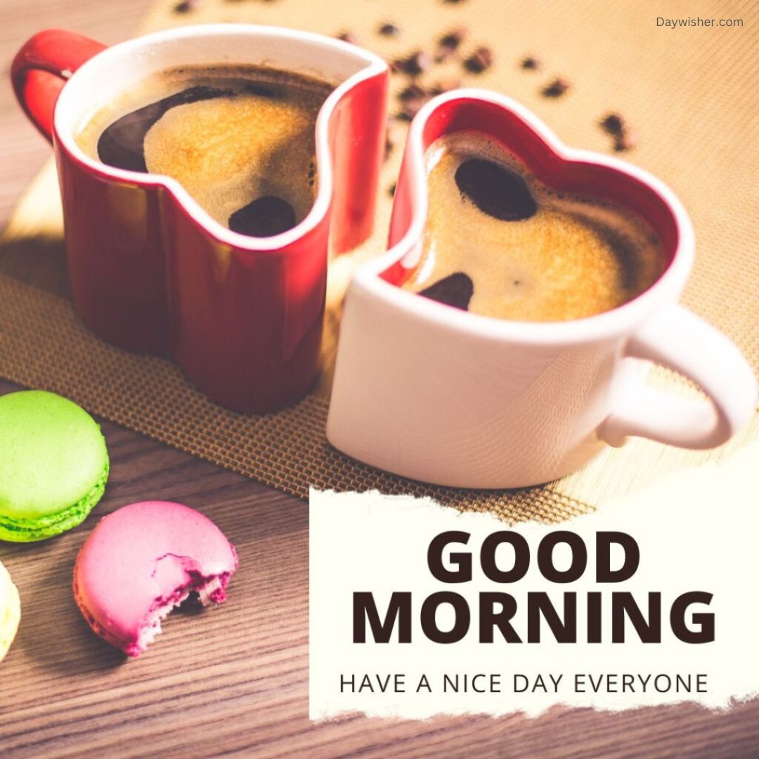 Two heart-shaped mugs filled with coffee placed next to colorful macarons, with a "Good Morning Love - have a nice day everyone" message.