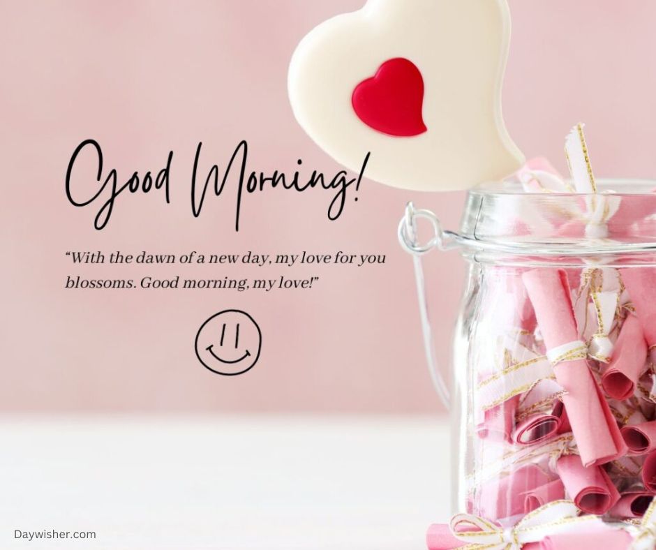 A jar filled with pink rolled notes tied with golden ribbons, next to a heart-shaped lollipop, against a soft pink background. Overlay text reads "Good Morning Love!" with a sentimental quote.