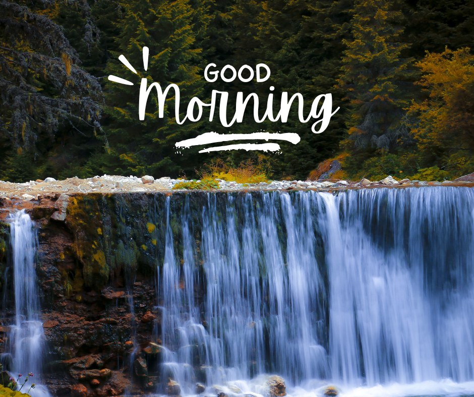 A stunning image of a waterfall cascading over rocks with a forest in the background. The text "Good Morning" is artistically displayed above the waterfall. This beautiful good morning nature image captures the serene and refreshing essence of nature, making it perfect for a peaceful start to the day. Suitable for WhatsApp and social media sharing, this new good morning nature image offers a calming landscape view.